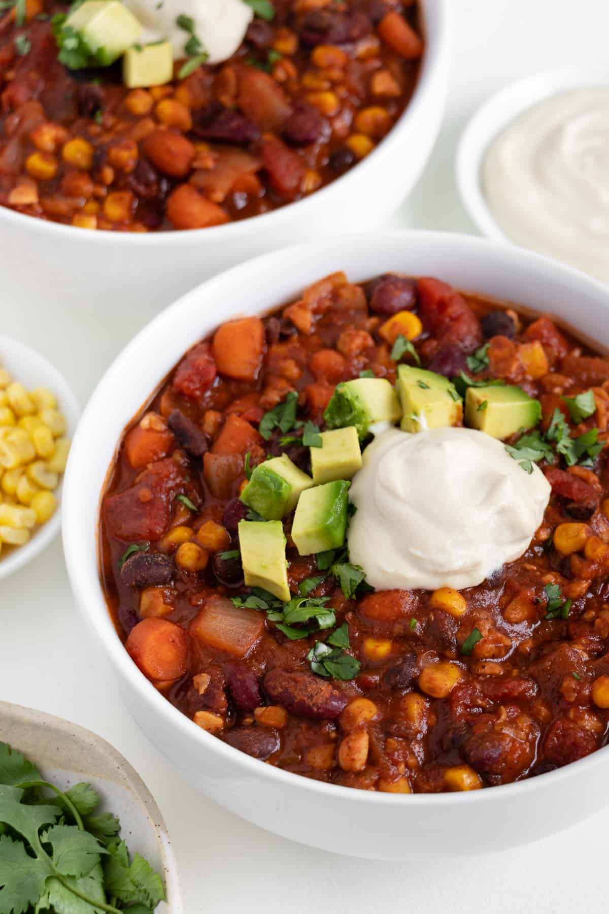 vegetarian tempeh chili topped with cashew sour cream, avocado, and cilantro