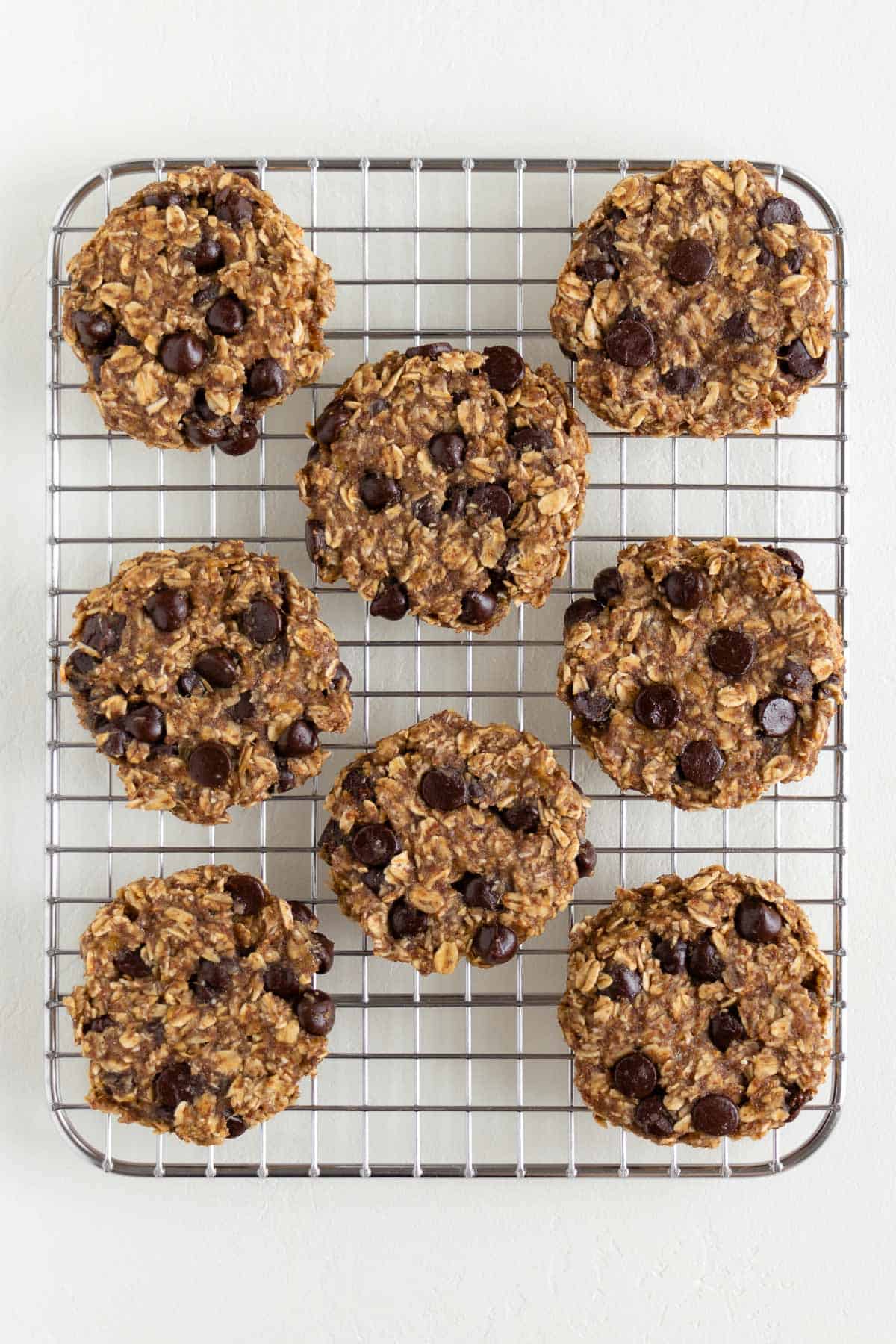 eight banana oatmeal chocolate chip cookies on a wire cooling rack