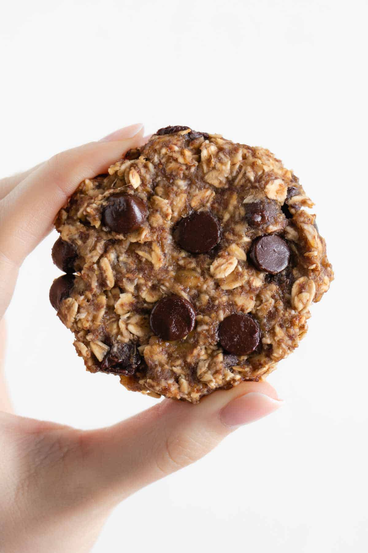 a hand holding a banana oatmeal cookie