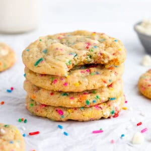 a stack of vegan birthday cake cookies with white chocolate chips and rainbow sprinkles