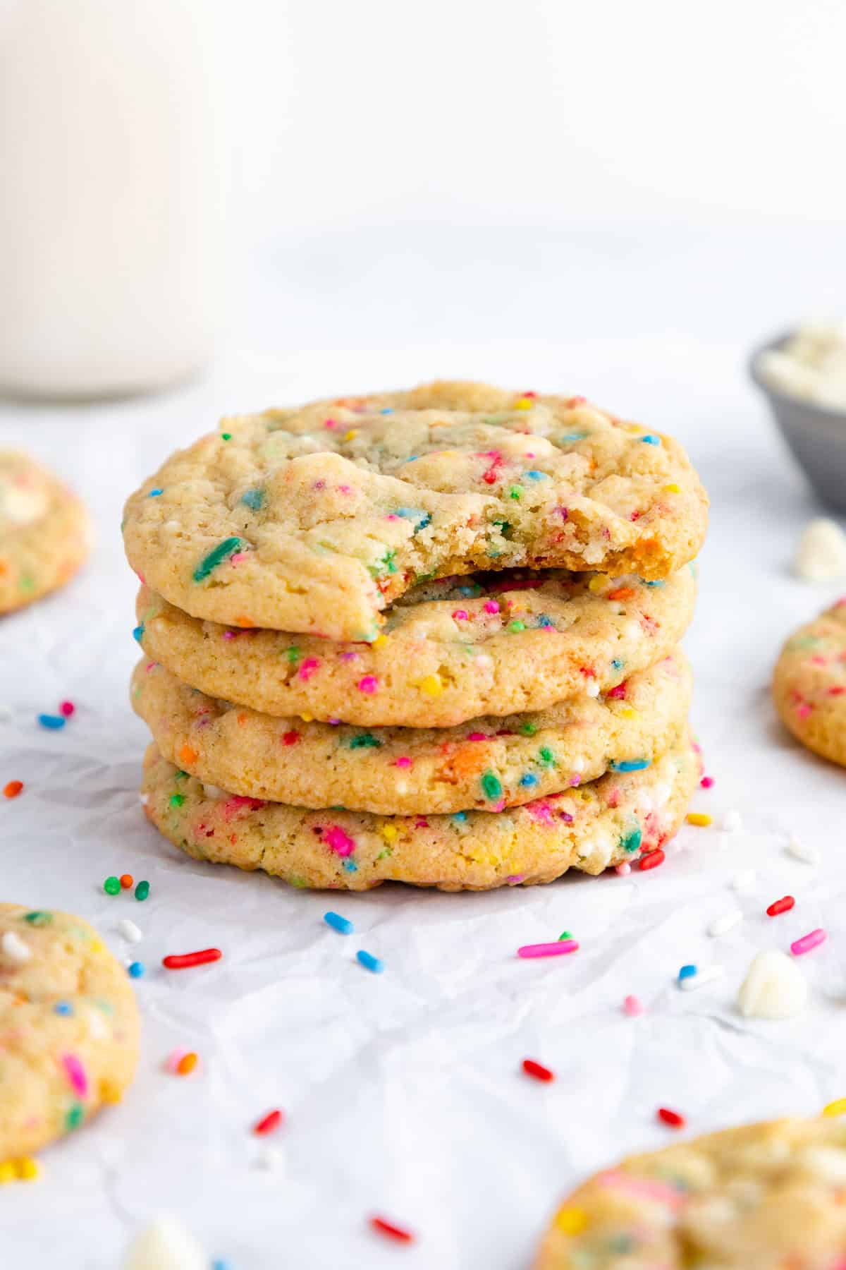 five vegan funfetti birthday cookies surrounded by rainbow sprinkles