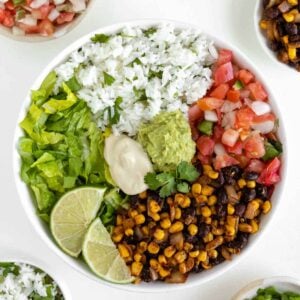 vegan burrito bowl with black beans, corn, cilantro lime rice, pico de gallo, lettuce, guacamole, and cashew sour cream