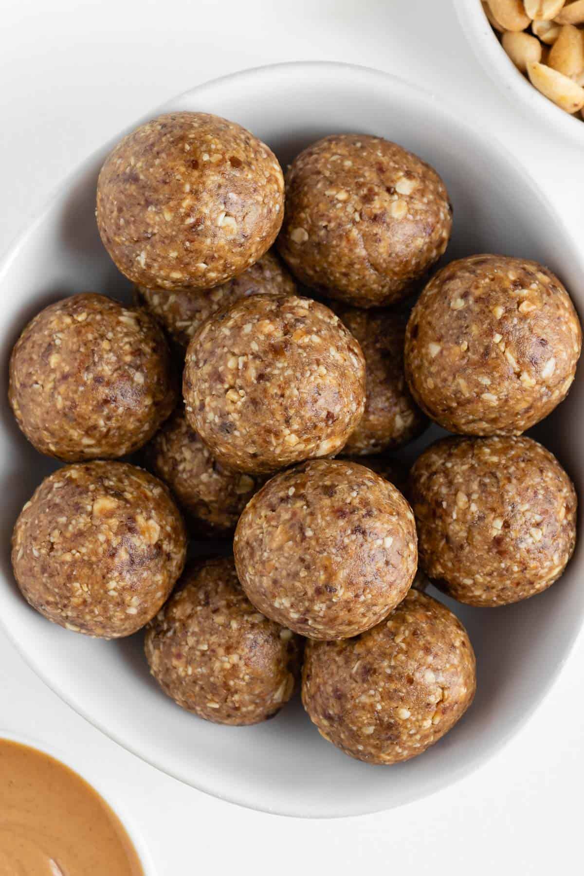 peanut butter energy balls stacked inside a white bowl