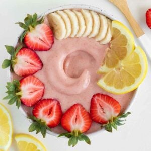 strawberry lemonade smoothie bowl surrounded by lemon slices and strawberries