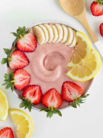 strawberry lemonade smoothie bowl surrounded by lemon slices and strawberries