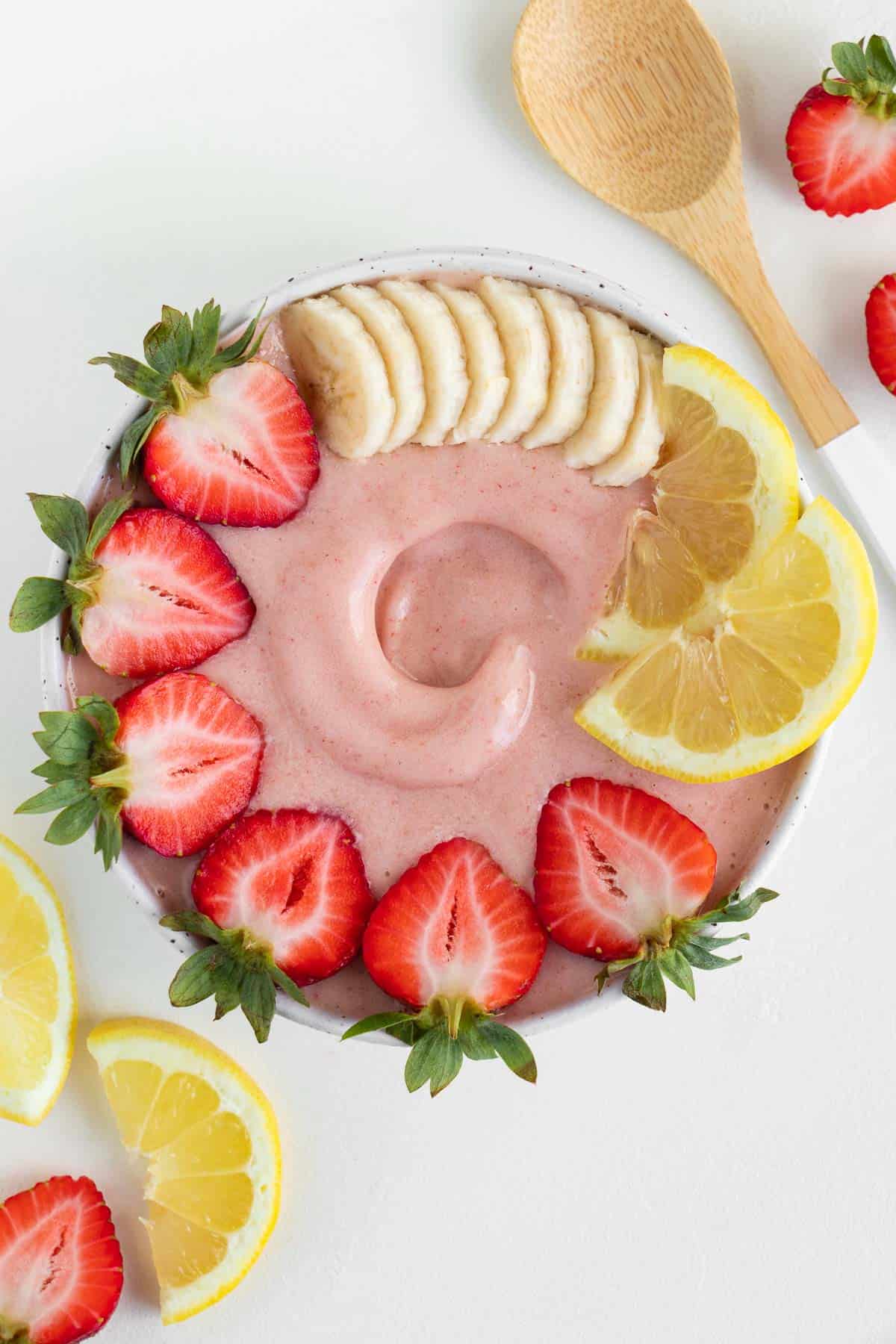 strawberry lemonade smoothie bowl surrounded by lemon slices and strawberries