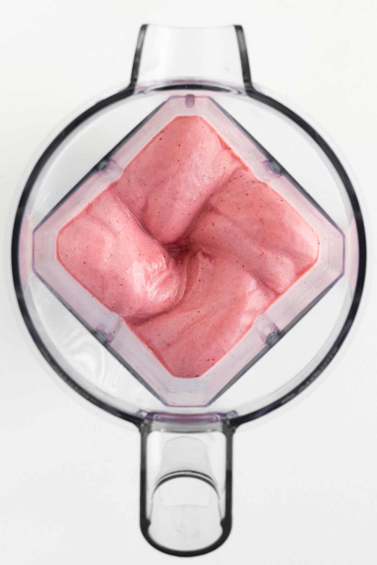 a creamy pink smoothie swirled inside a blender