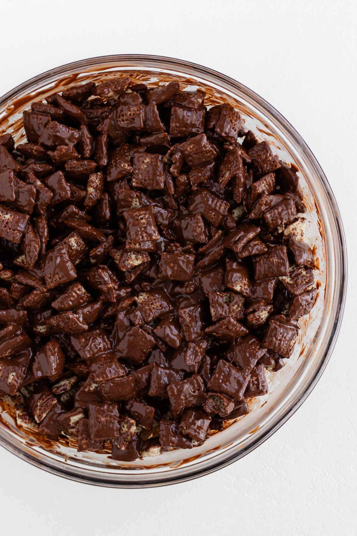 chocolate covered chex cereal in a large glass bowl
