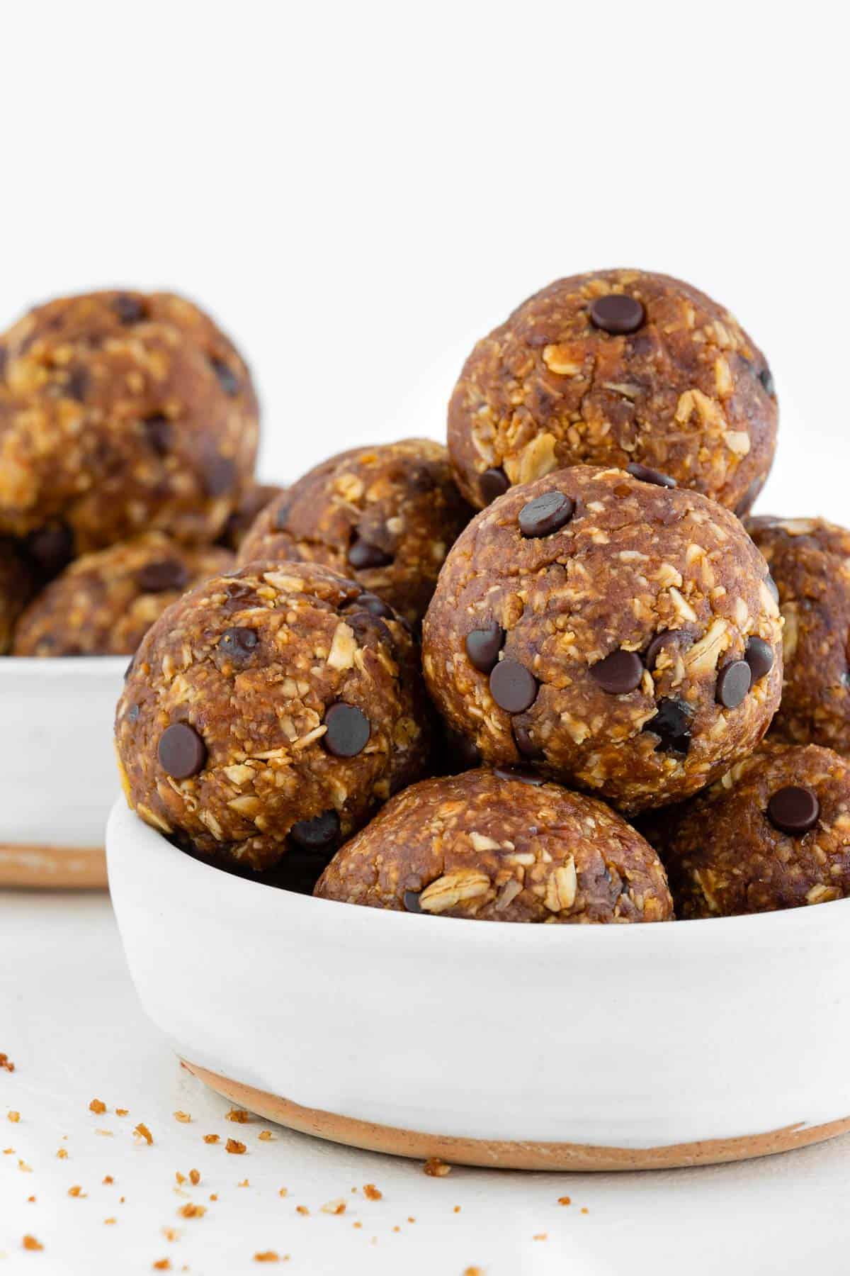 chocolate chip pumpkin energy balls stacked inside two white bowls