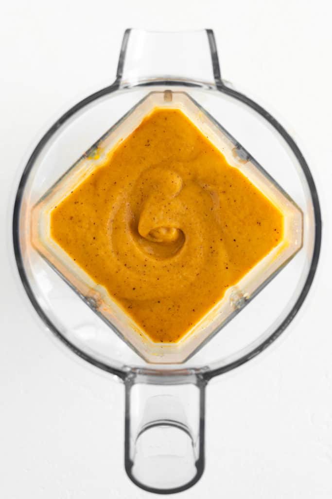 an orange smoothie inside a blender