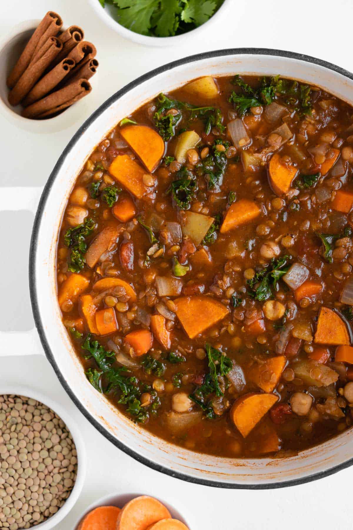 a large white pot filled with sweet potato, chickpea, and lentil stew