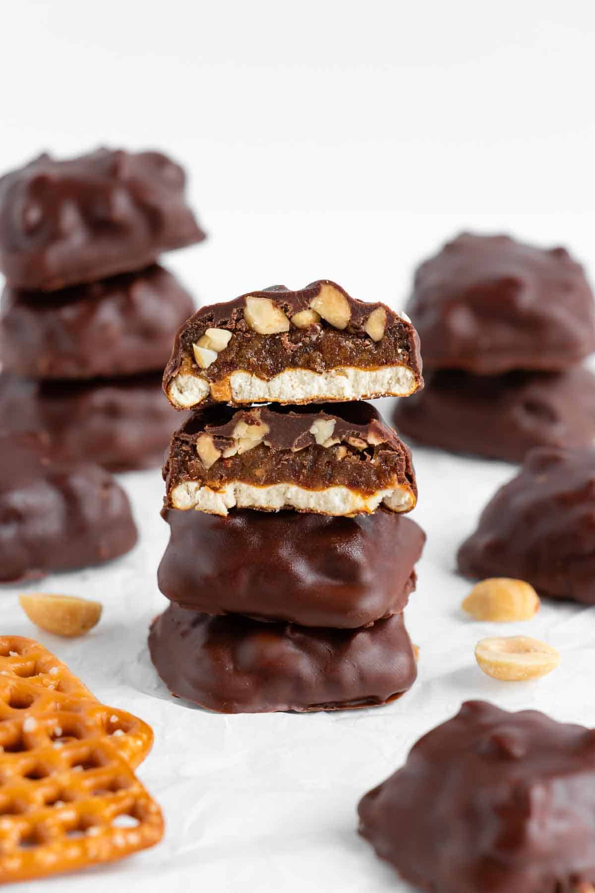 four vegan homemade take 5 candy bars stacked on top of each other, with bites taken out of the top two bars