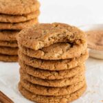 two tall stacks of vegan snickerdoodle cookies with a bite taken out of the top cookie