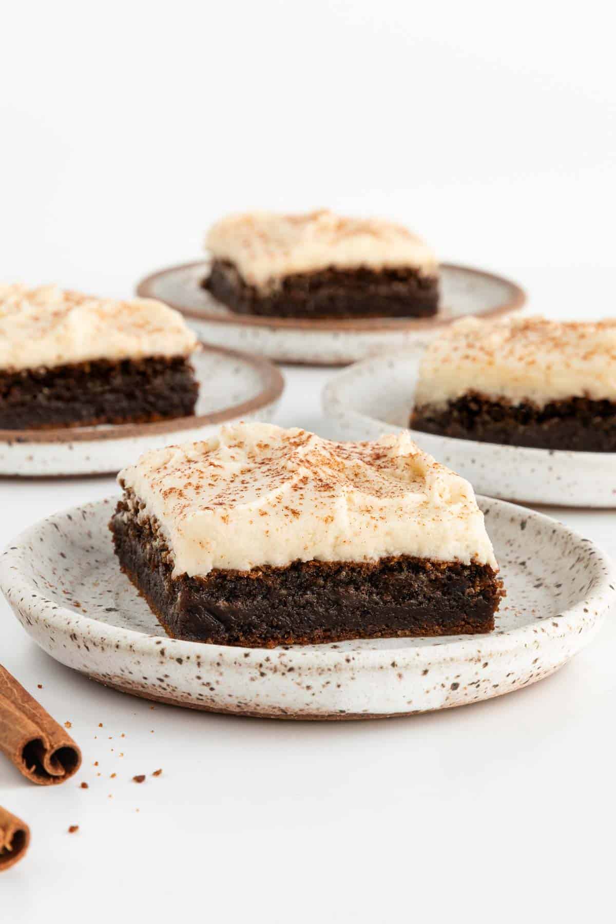 four frosted vegan gingerbread cookie bars on ceramic plates