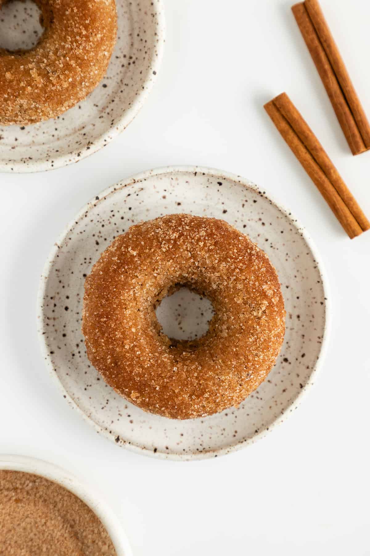 a vegan cinnamon sugar donut on a small ceramic plate