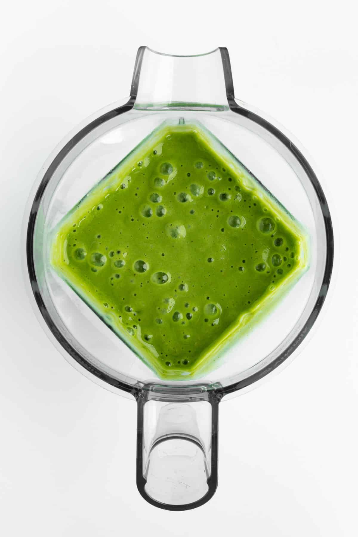 a green smoothie blended inside a blender