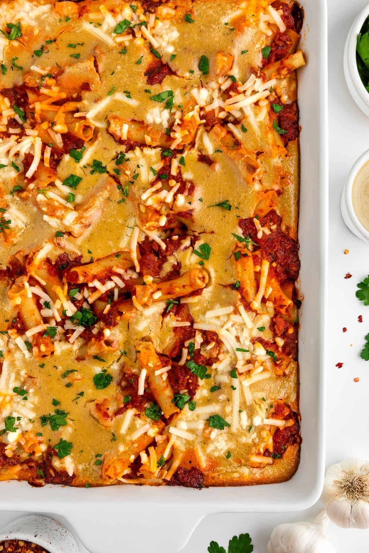 a close up image of vegan baked ziti in a white casserole dish