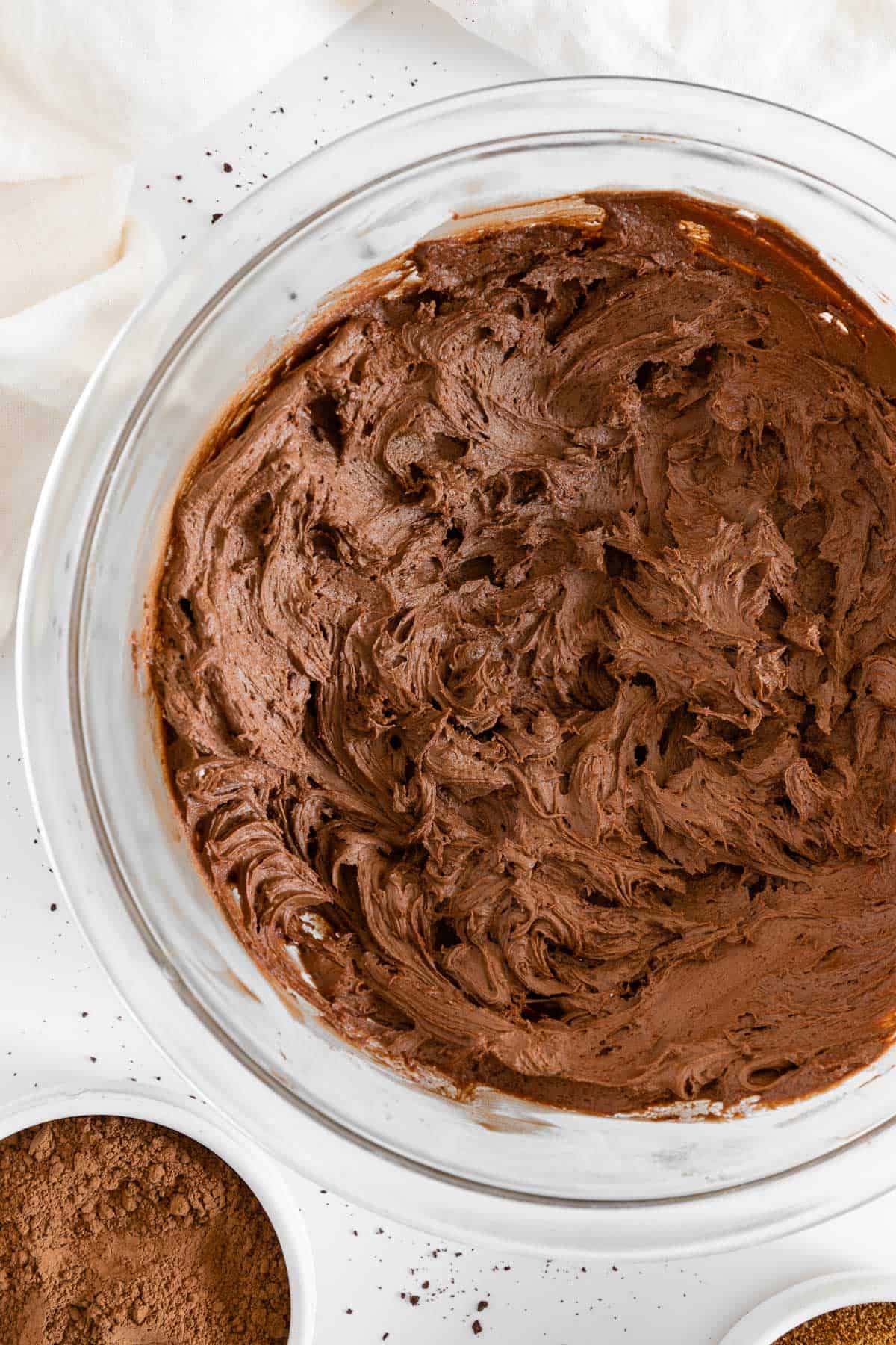 vegan chocolate buttercream frosting inside a large glass mixing bowl