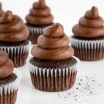 five vegan chocolate cupcakes with chocolate buttercream frosting on top
