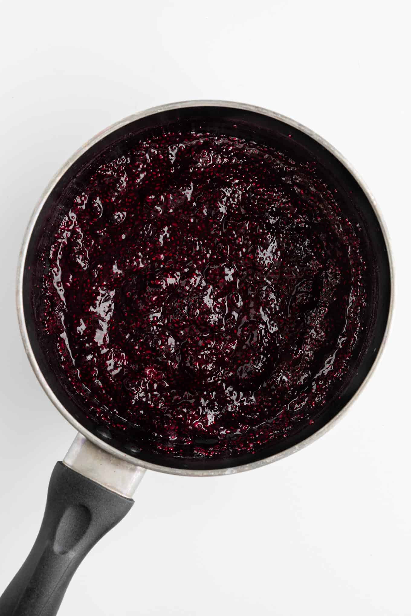 berry chia jam cooked inside a small black sauce pot