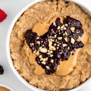 close up image of peanut butter and jelly oatmeal inside a white bowl