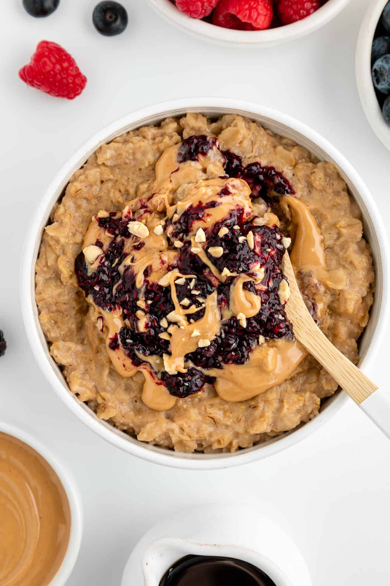 a spoon scooping into a bowl of peanut butter and jelly oatmeal