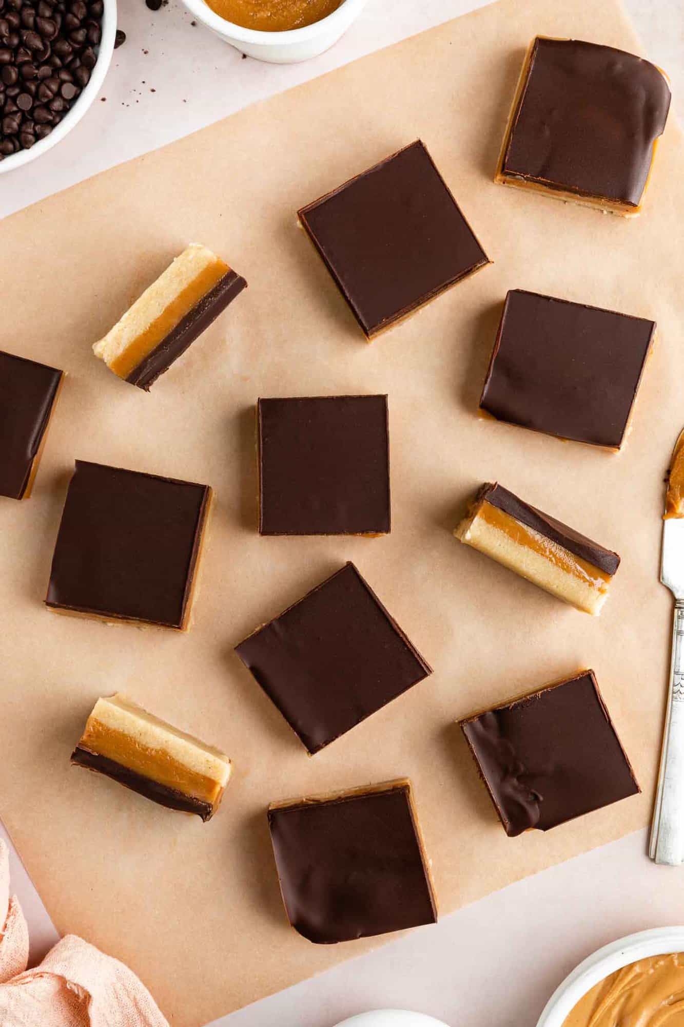 squares of no-bake vegan millionaire shortbread laid out on a square of brown parchment paper