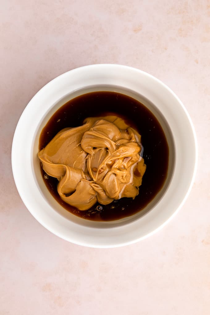 peanut butter, maple syrup, and coconut oil inside a white bowl