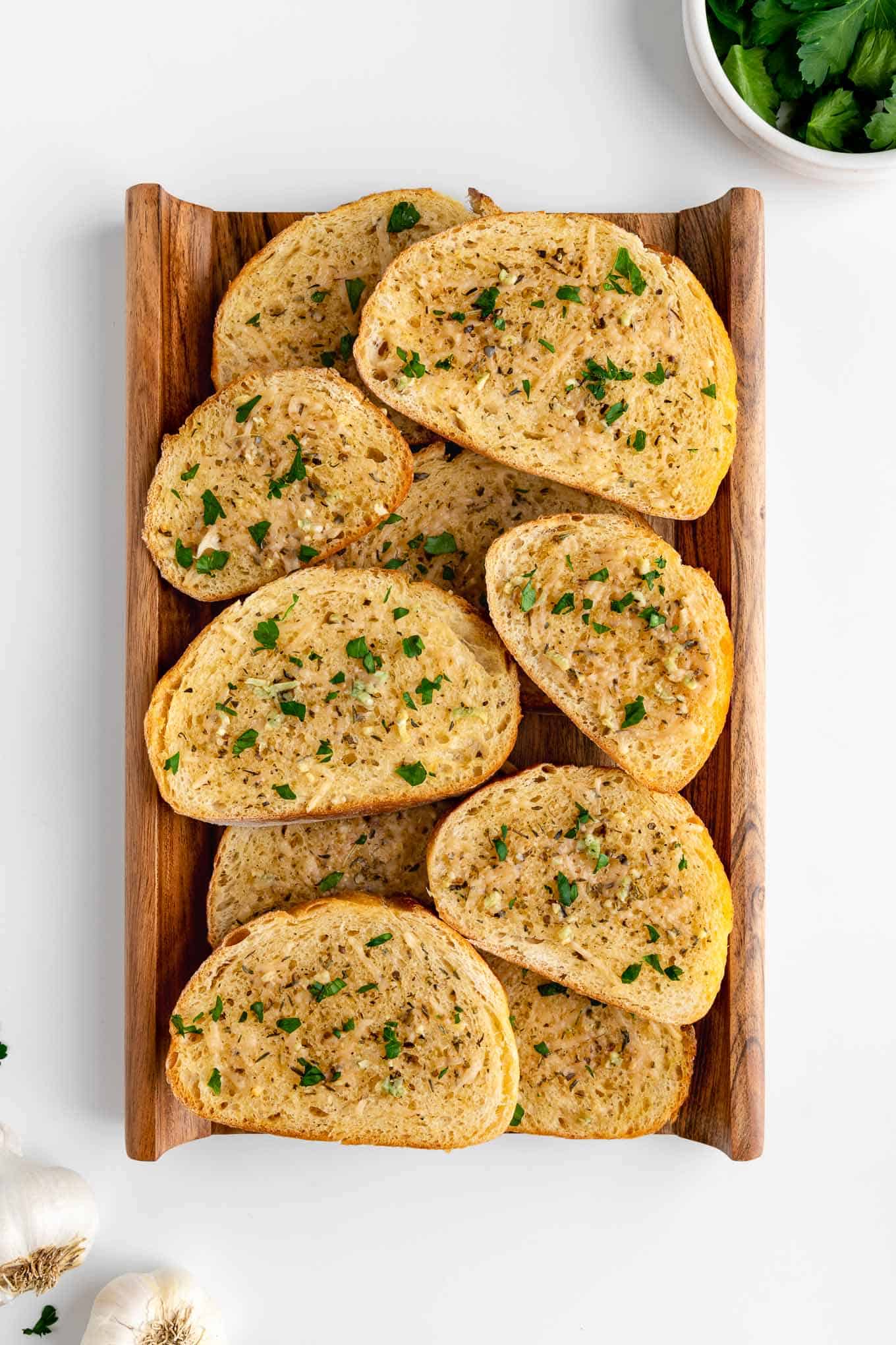 a wood board topped with slices of vegan garlic bread