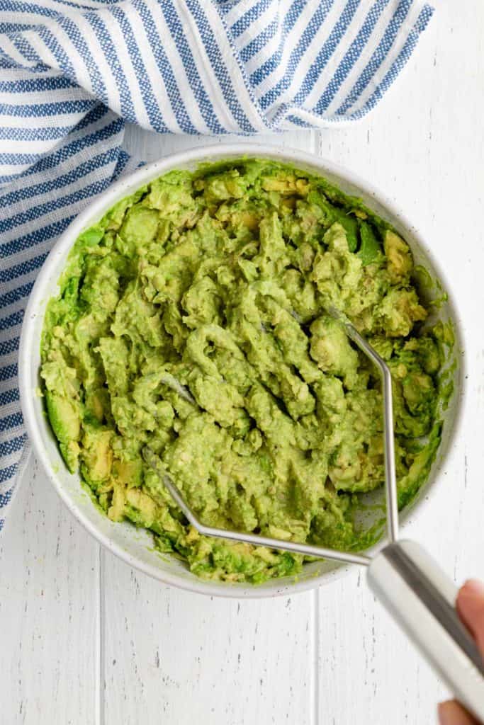 mashing avocado in a bowl