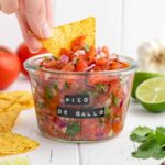 tortilla chip scooping pico de gallo from a weck jar