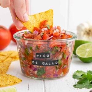 tortilla chip scooping pico de gallo from a weck jar