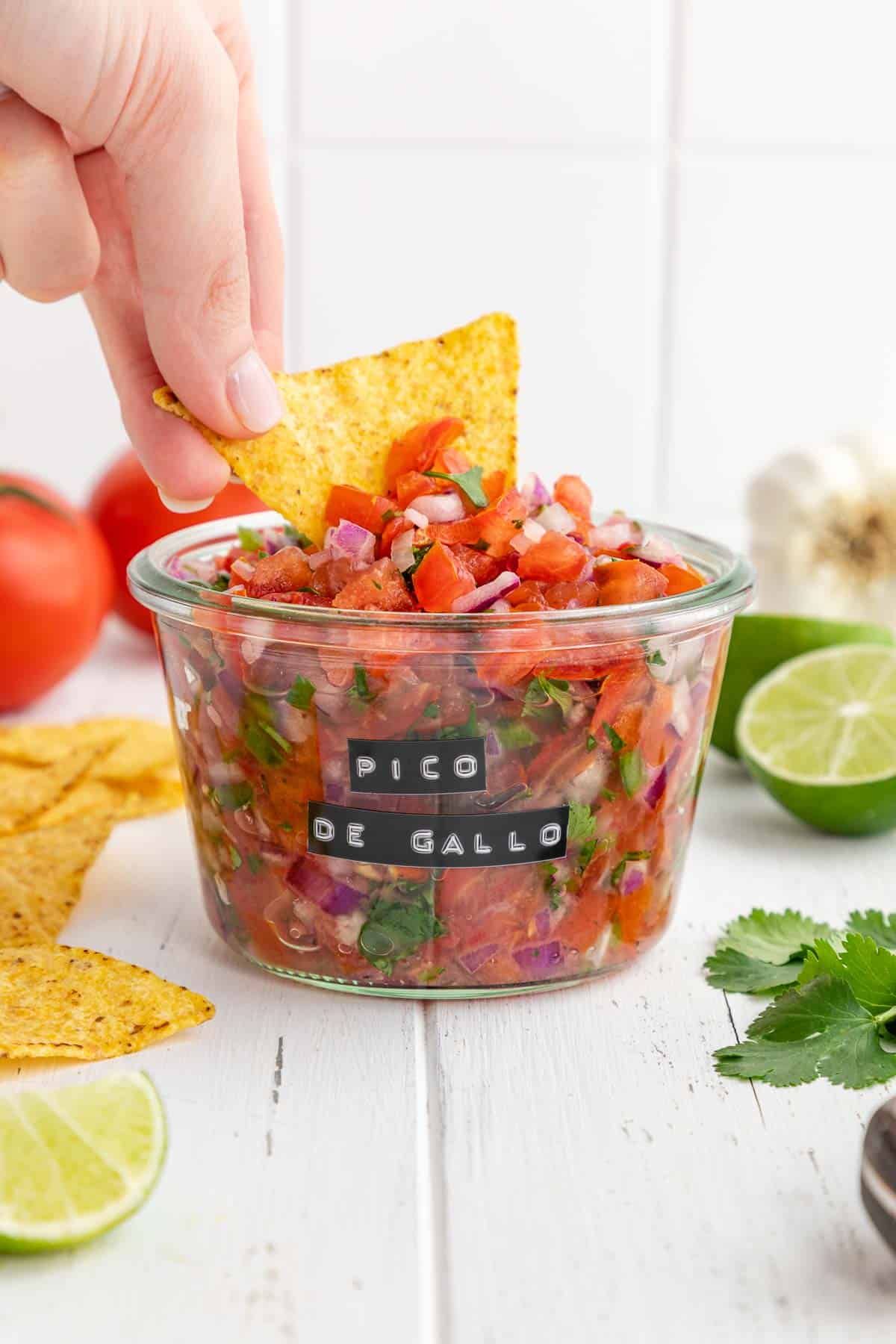 tortilla chip scooping pico de gallo from a weck jar