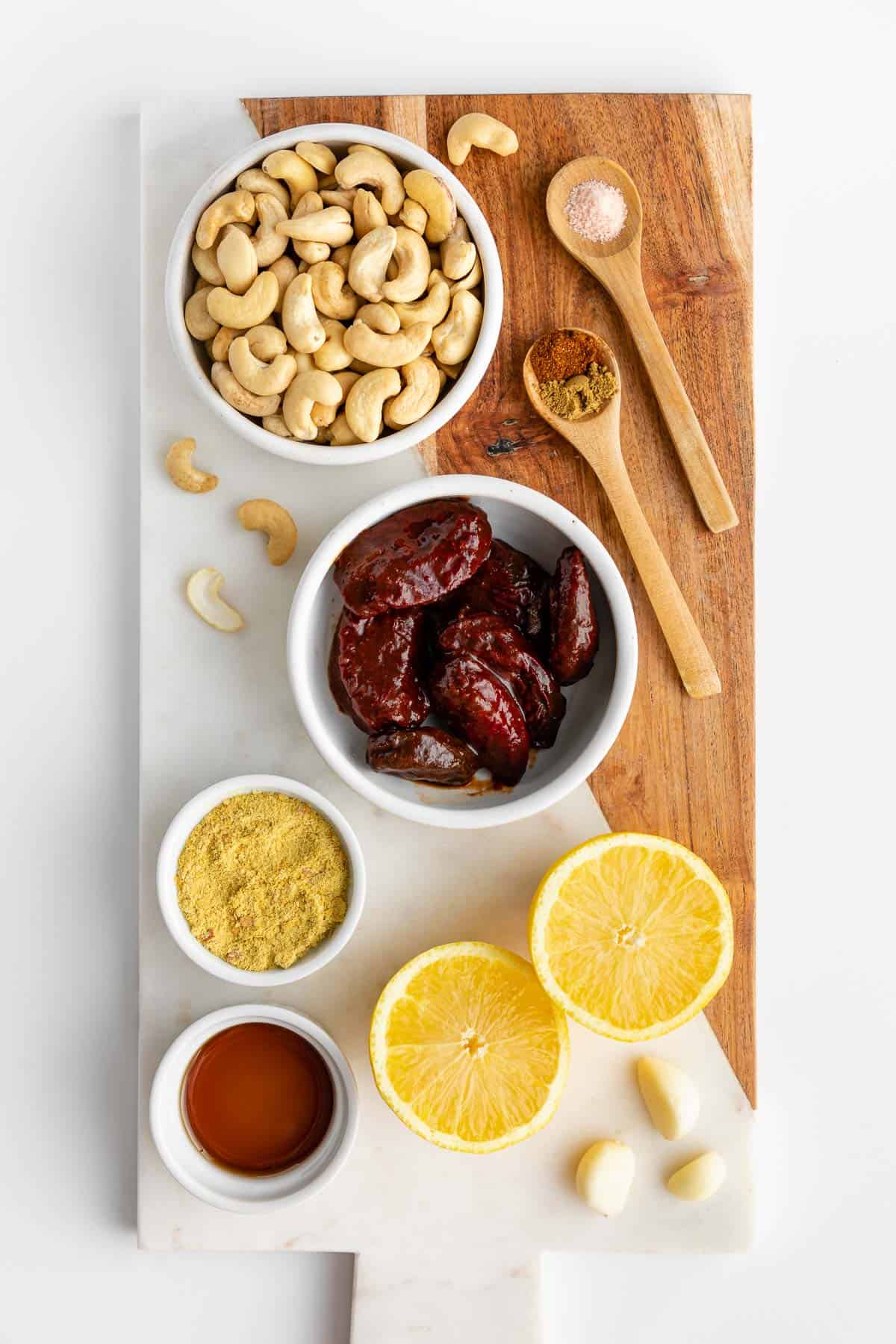 cashews, chipotle peppers in adobo sauce, lemon, nutritional yeast, maple syrup, and spices on a marble serving board