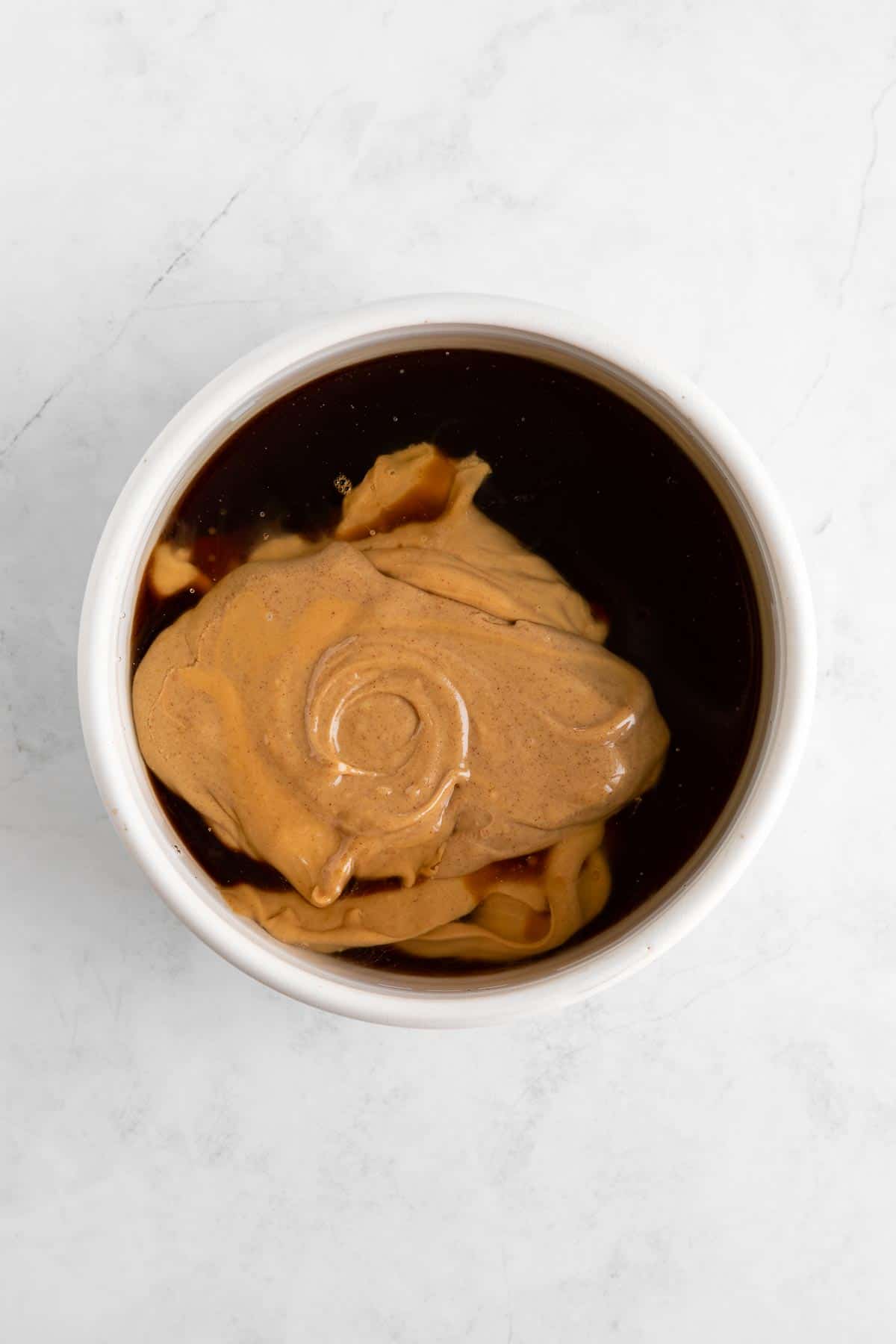 peanut butter, maple syrup, and coconut oil in a white bowl