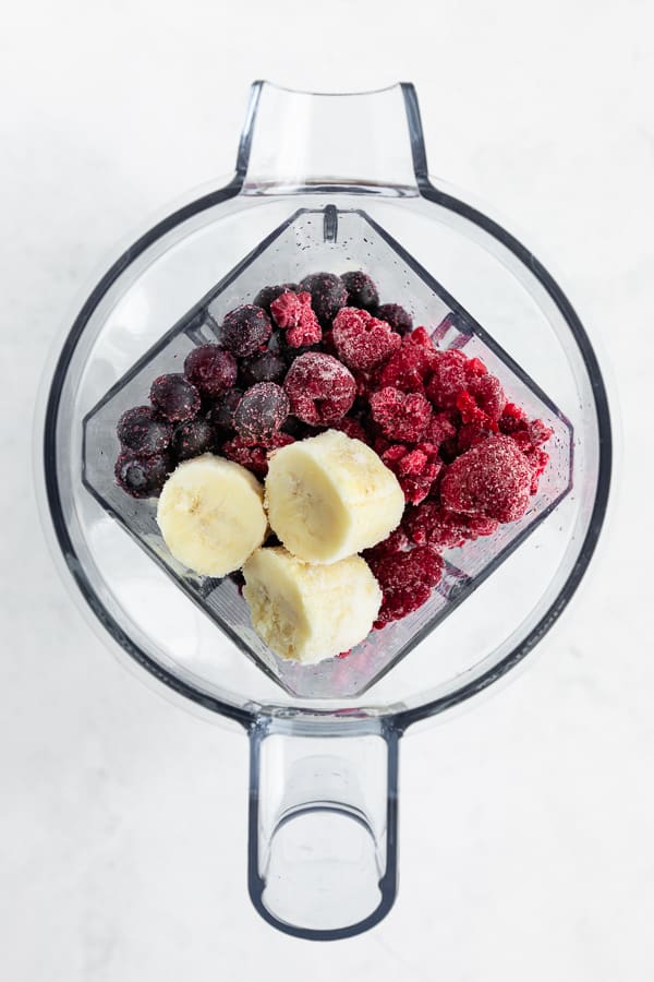 frozen blueberries, frozen raspberries, and frozen bananas in a vitamix blender