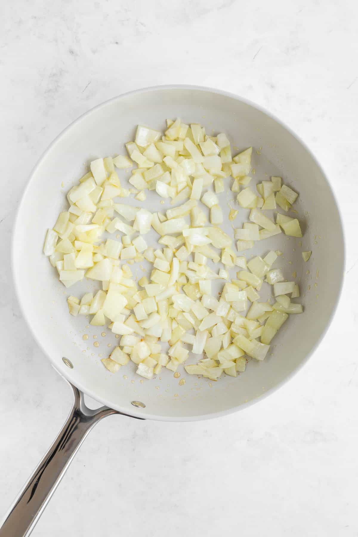 diced onion and oil frying on a pan