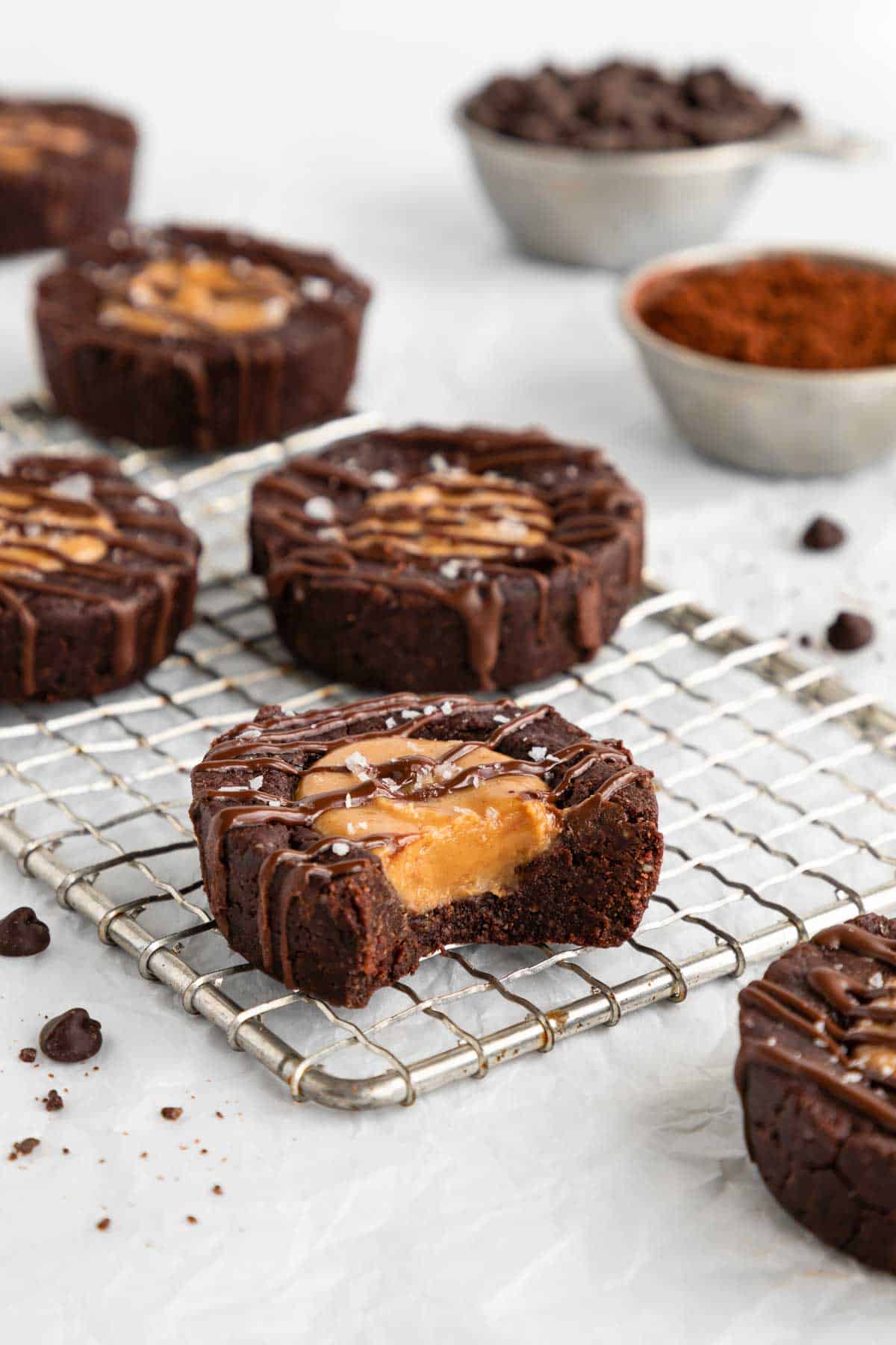 no bake peanut butter brownie cups on a wire cooling rack with a bite taken out of the middle