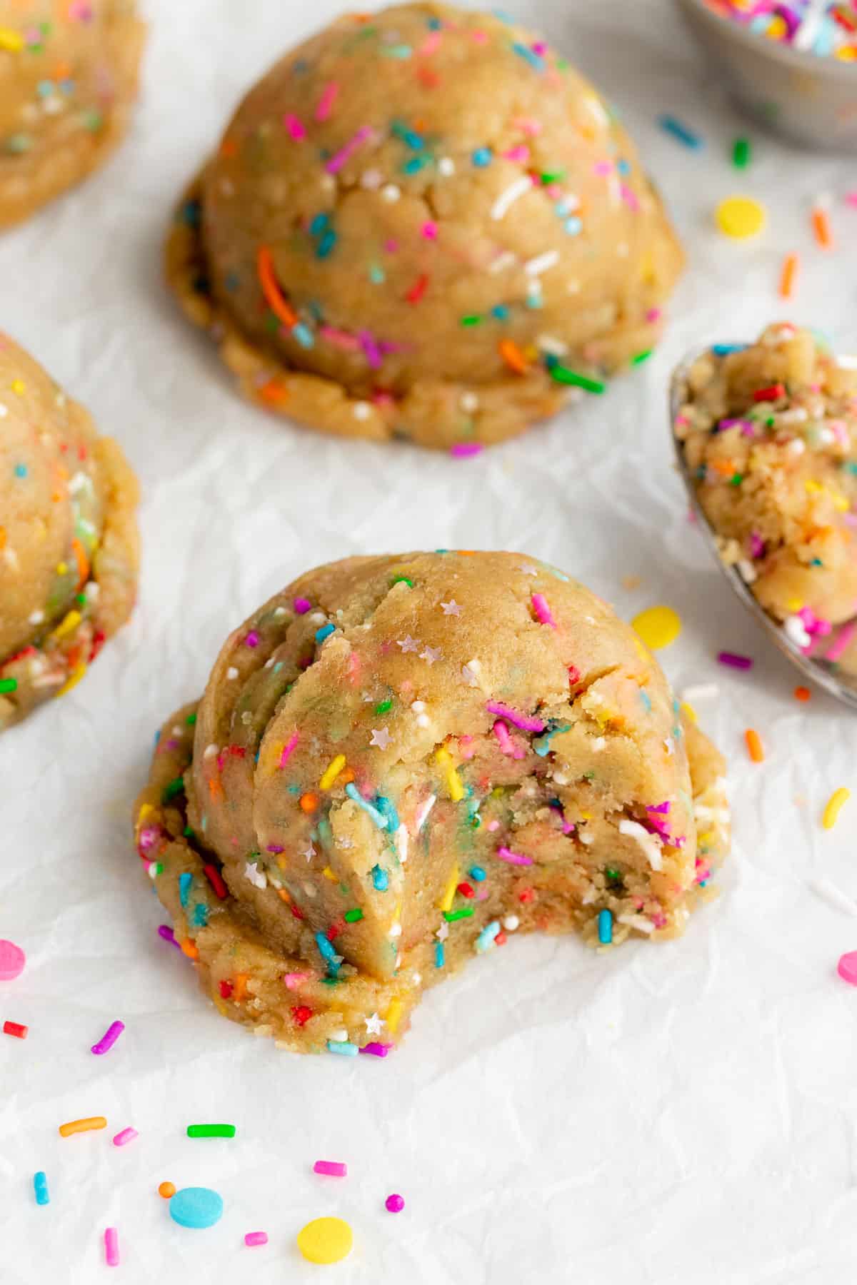 scoops of edible funfetti cookie dough with a bite taken out of the center