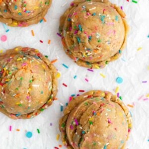 four large rounds of edible funfetti cookie dough with vegan rainbow sprinkles