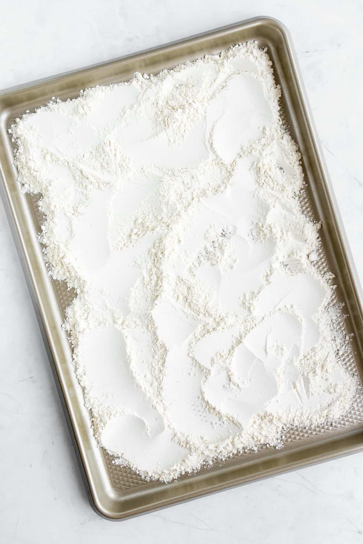 all purpose flour spread on a baking sheet