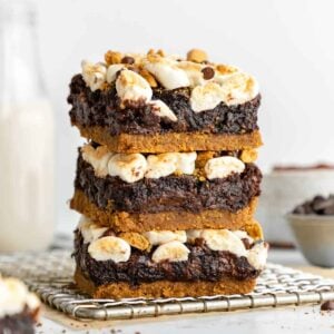 a stack of three vegan s'mores brownies on a wire cooling rack