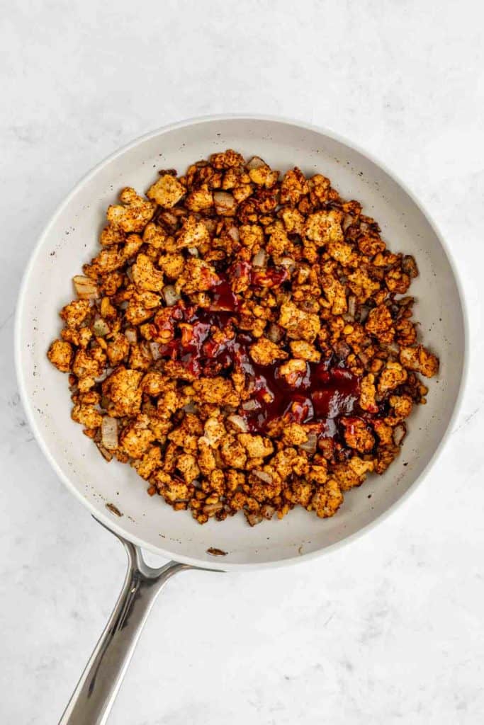 crumbled tempeh and marinade in a ceramic frying pan