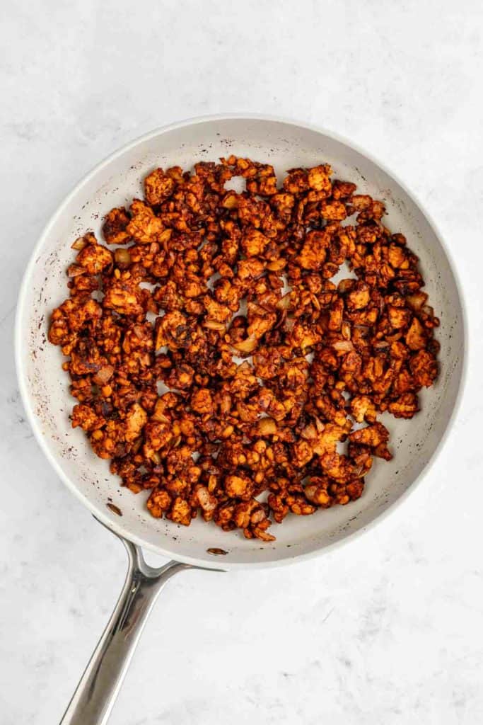 cooking spicy tempeh chorizo in a ceramic frying pan