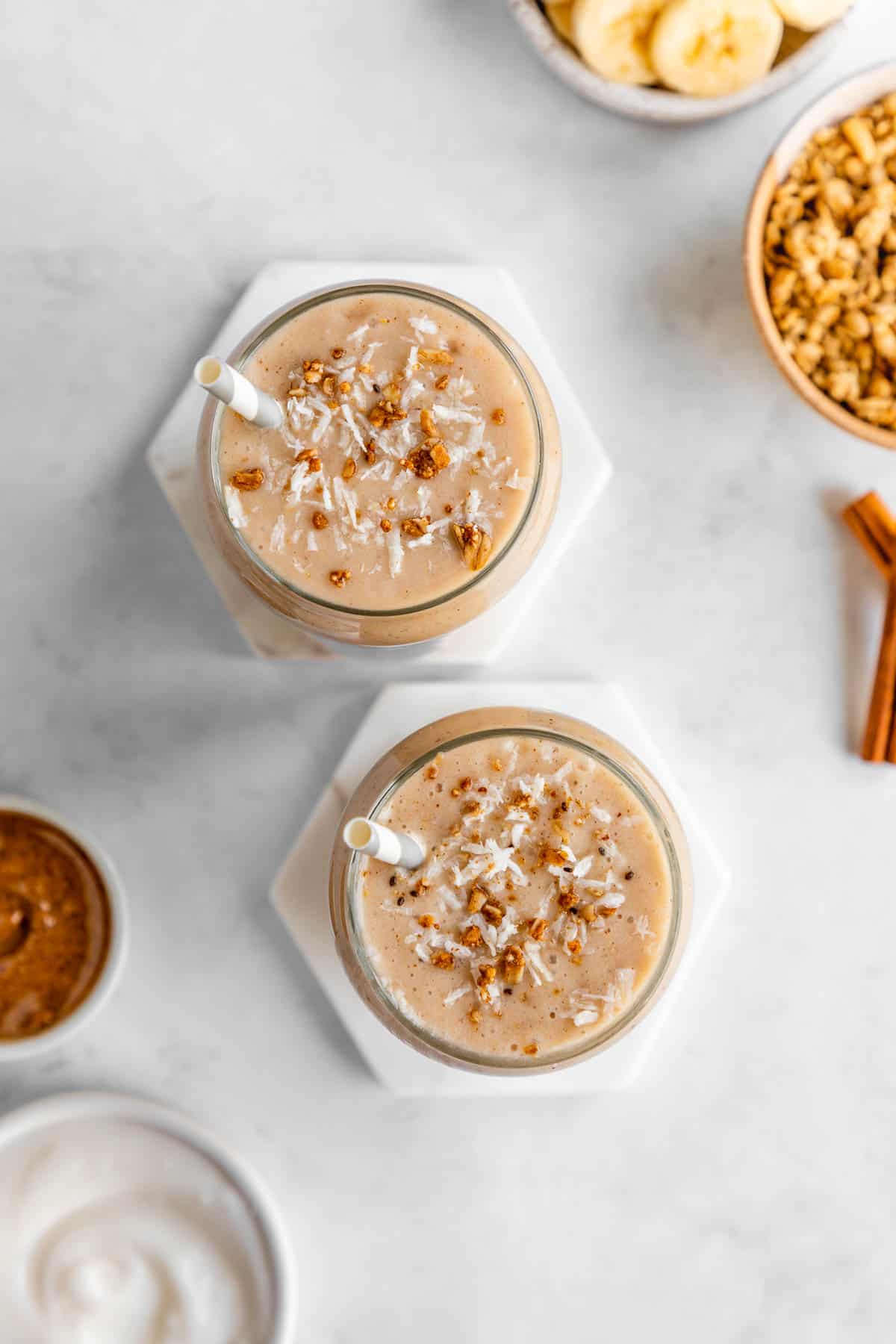 overhead photo of two glasses filled with banana almond butter smoothie