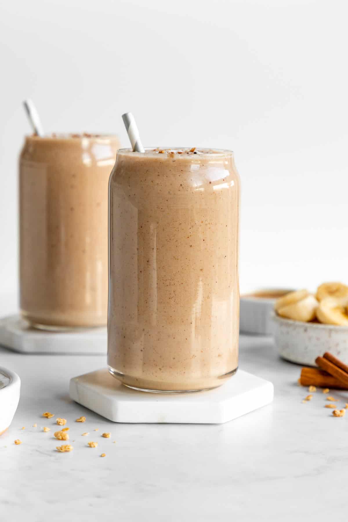 two glasses filled with banana almond butter smoothie