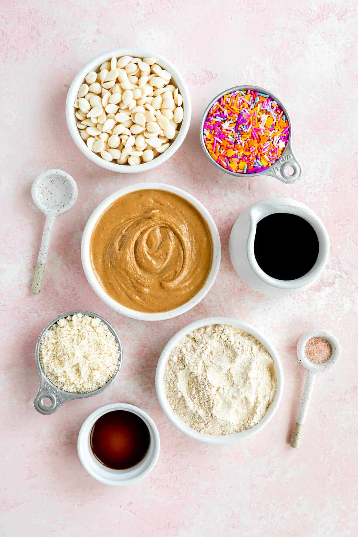 bowls of cashew butter, birthday cake protein powder, almond flour, maple syrup, sprinkles, vanilla extract, and almond extract