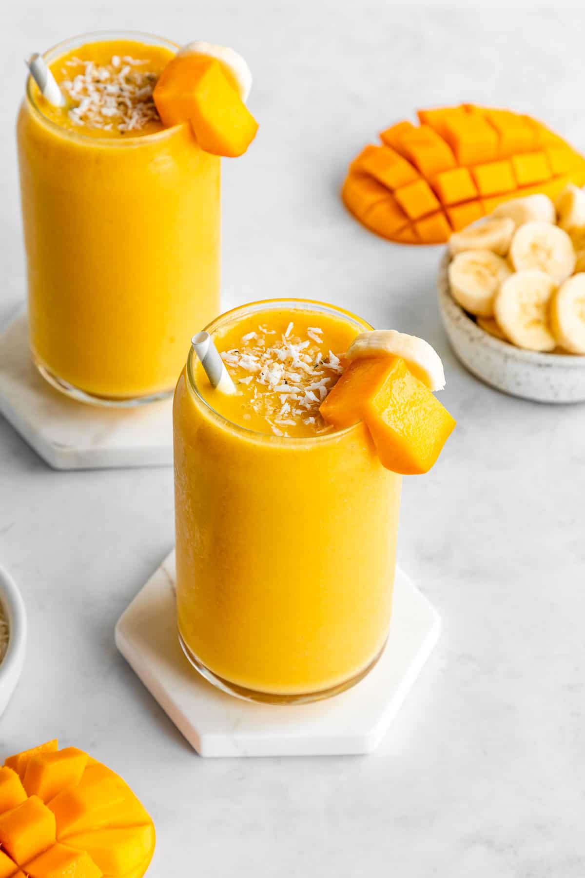 mango banana smoothie inside two glasses