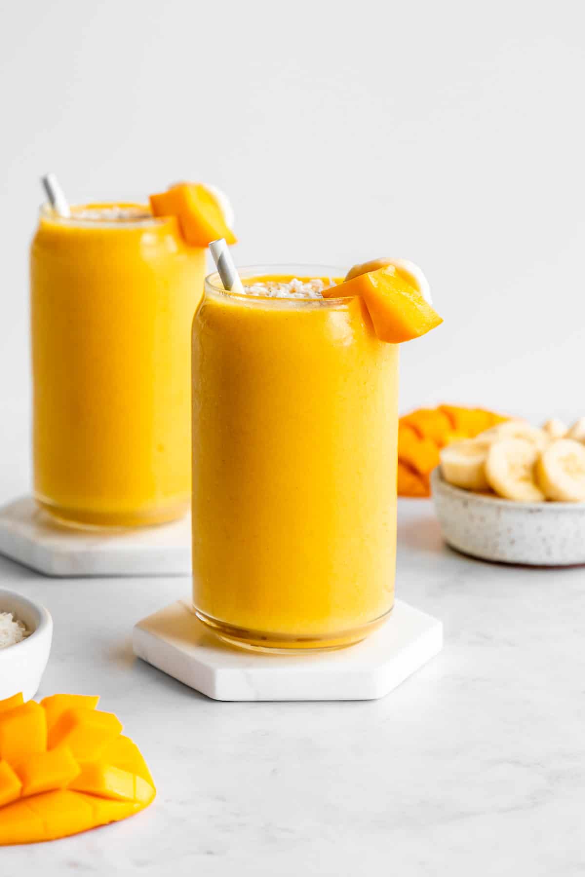 two mango banana smoothie glasses
