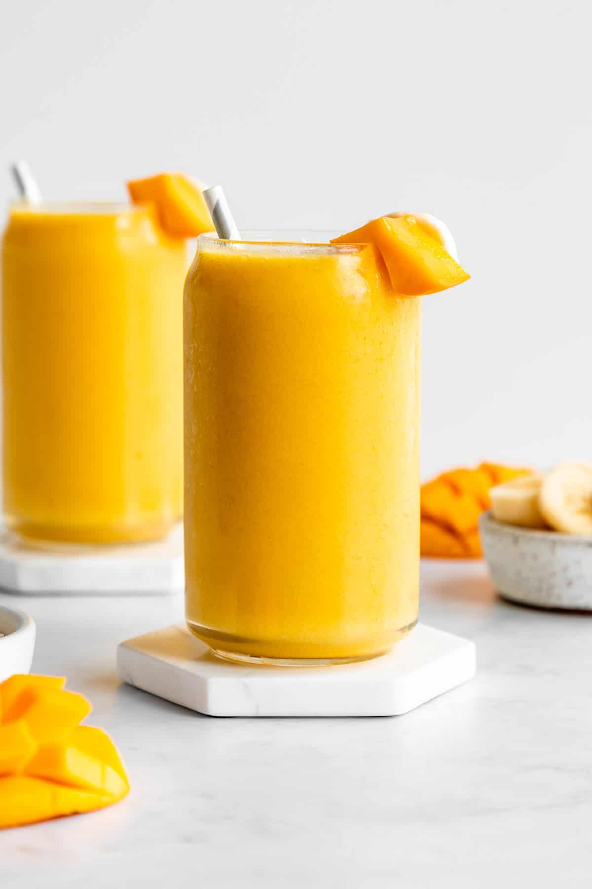 mango banana smoothie inside two glasses